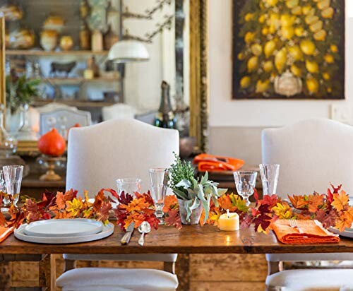 Dining table decorated with autumn leaves and candles.