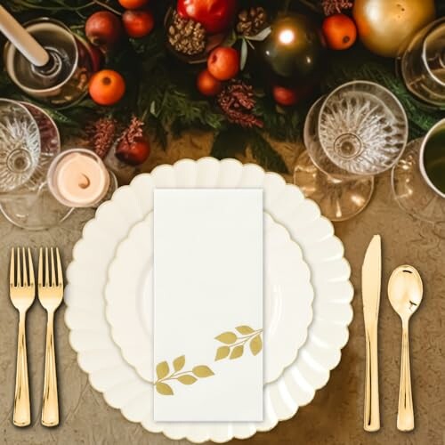 Elegant table setting with plates, cutlery, and festive decor.